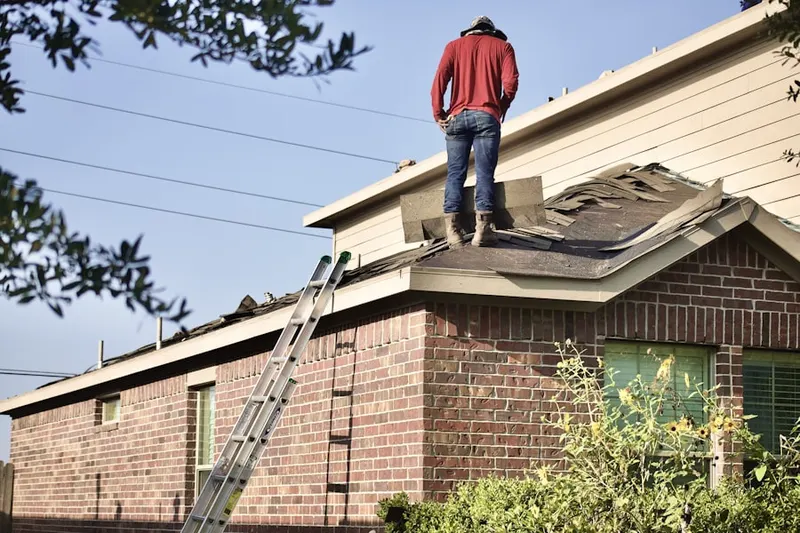 Professional roofer working on a residential roof in Great Neck Estates
